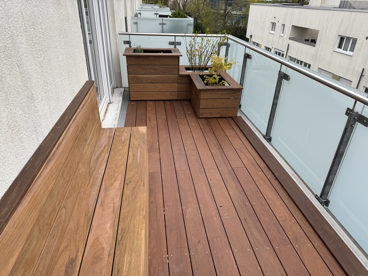 Holzterrasse mit Bank und Blumenkästen, alles in warmem Braunton gestaltet